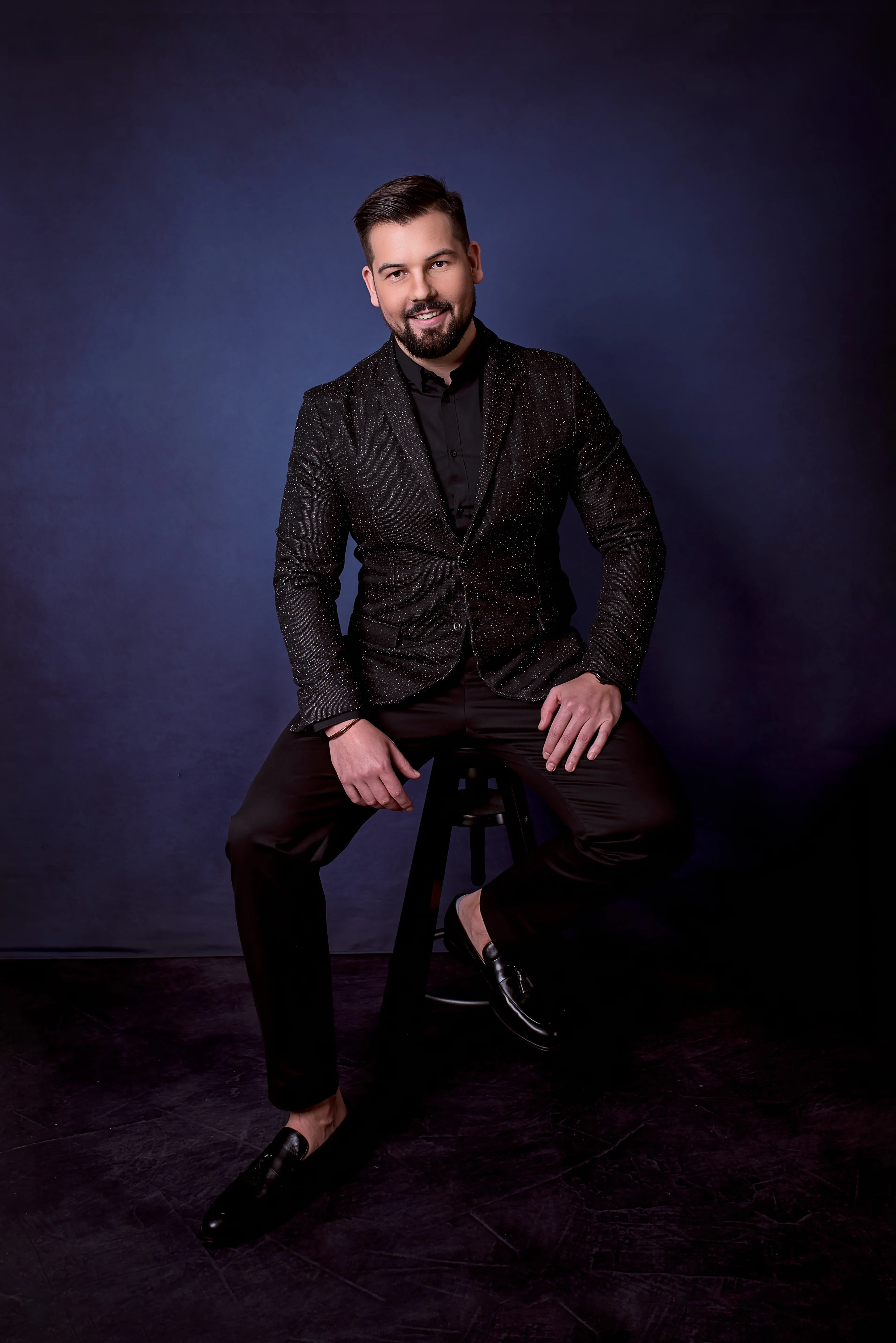 Rafał Furgała — elegancki portret studyjny na granatowym tle